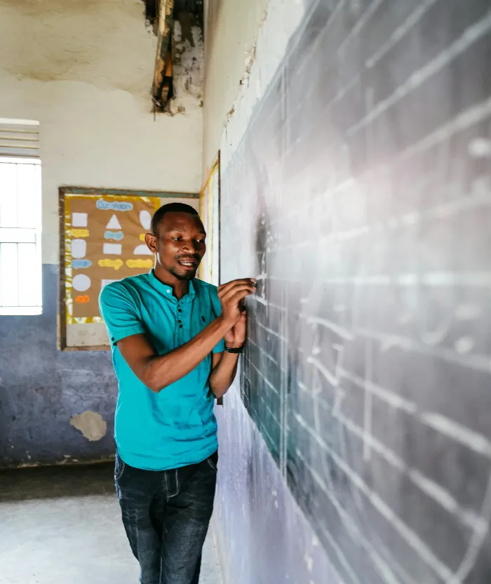 A Ugandan teacher teaching in a classroom